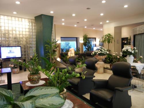 un salone con sala d'attesa con sedie e piante di Delle Nazioni Milan Hotel a Milano
