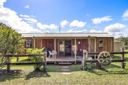 a wooden house with a porch and a fence at Country Cottage Sunshine Coast in Montville