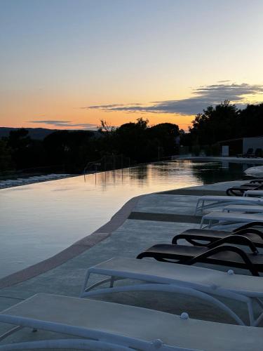 a row of chaise lounges sitting on the water at sunset at Mobile home Sunflower - Selce in Selce