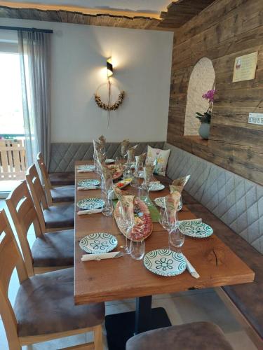 a wooden table with glasses and plates on it at Weingut Stoff in Kitzeck im Sausal