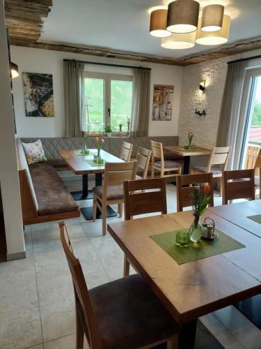 a restaurant with wooden tables and chairs and windows at Weingut Stoff in Kitzeck im Sausal