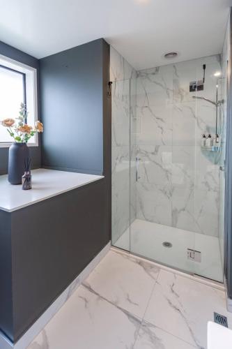 a bathroom with a shower with a glass door at Spacious 2BR, 2Bath Home Base on Gloucester Street in Christchurch