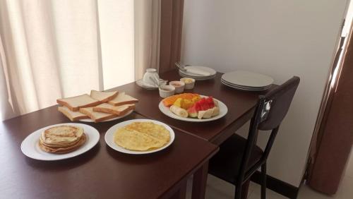 a table with plates of breakfast food on it at Kandy Alpine Breeze in Kandy