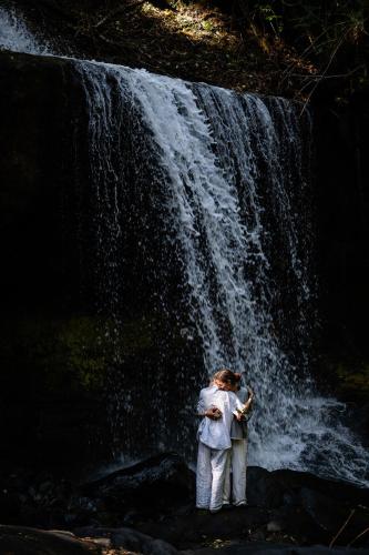 a woman standing in front of a waterfall at Koroi Forest Camp in Arusha