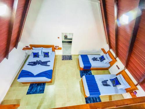 a room with three beds in a room at Lotus Eco Villa in Sigiriya