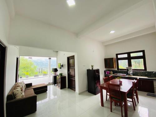 a kitchen and living room with a table and chairs at TK Homes in Badulla