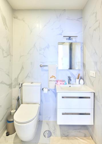 a white bathroom with a toilet and a sink at Apartamentos Golfinho Dourado in Santa Maria