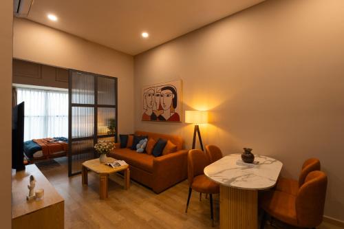 a living room with a couch and a table at DingD0ng Suites - The Sun Avenue - Free Pool & Gym in Ho Chi Minh City