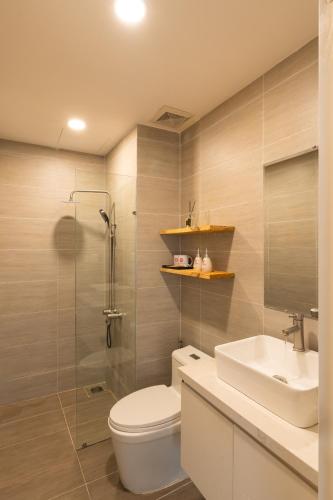 a bathroom with a toilet and a sink and a shower at DingD0ng Suites - The Sun Avenue - Free Pool & Gym in Ho Chi Minh City