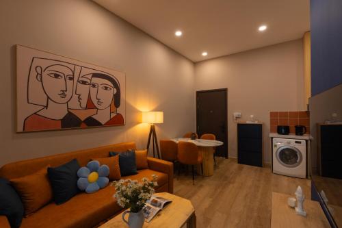 a living room with a couch and a painting on the wall at DingD0ng Suites - The Sun Avenue - Free Pool & Gym in Ho Chi Minh City