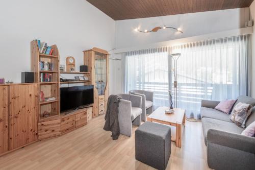 a living room with a couch and a tv at Zuhause in den Alpen Ihre Ferienwohnung mit Hallenbad und Sauna in Lenzerheide