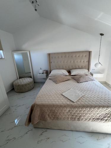 a bedroom with a large bed and a mirror at Perla in Stinica