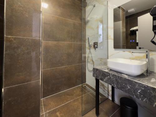 ein Badezimmer mit Waschbecken und Dusche in der Unterkunft ES Hotel in Tirana