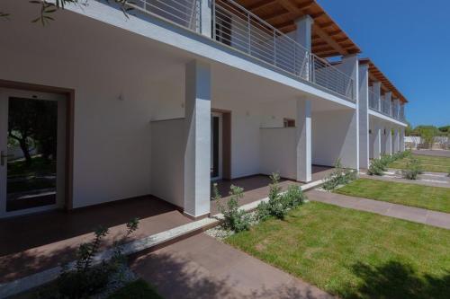 a white house with a balcony and a yard at Resort La Ficaccia in La Marmorata