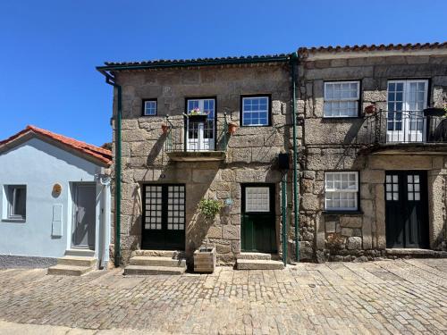 an old stone house with a cobblestone courtyard at Casa da Muralha Cerveira in Vila Nova de Cerveira