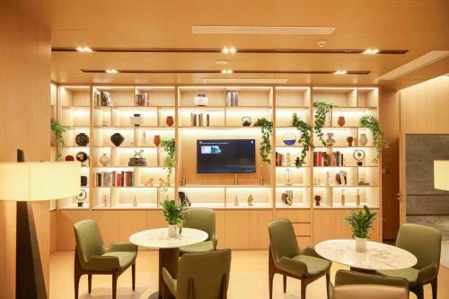 a room with two tables and chairs and a tv at Oakwood Central Wuxi in Wuxi