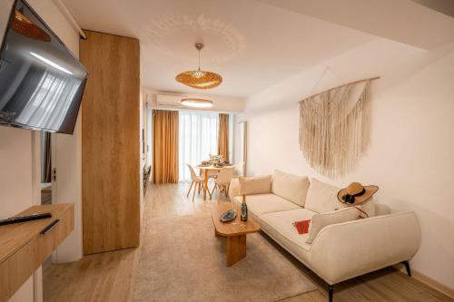 a living room with a white couch and a table at Lotti in Infinity Pool & Spa Resort in Mamaia