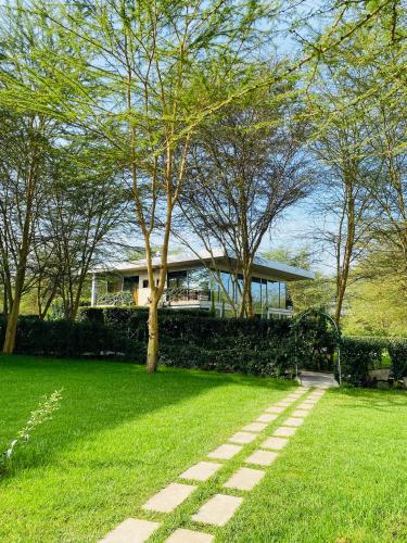 a house in the middle of a grassy yard at Lake Elementaita Manor in Gilgil