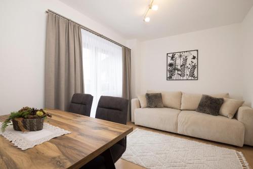 a living room with a table and a couch at Appartements Huber in Fügen