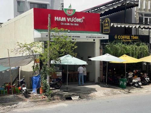 a man standing outside of a building with umbrellas at DingD0ng Suites - The Sun Avenue - Free Pool & Gym in Ho Chi Minh City