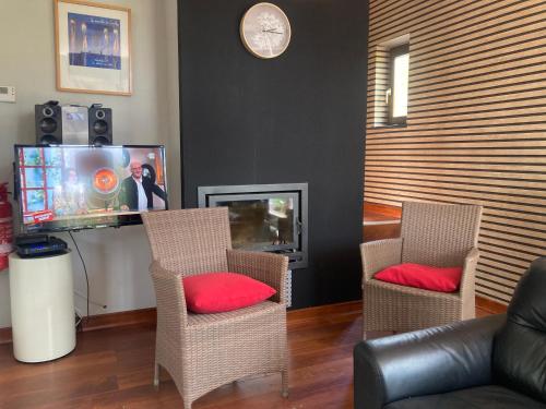 a living room with two chairs and a tv at Gite-ardennes & wellness - Ovifat - Coquelicots 7 pers in Ovifat