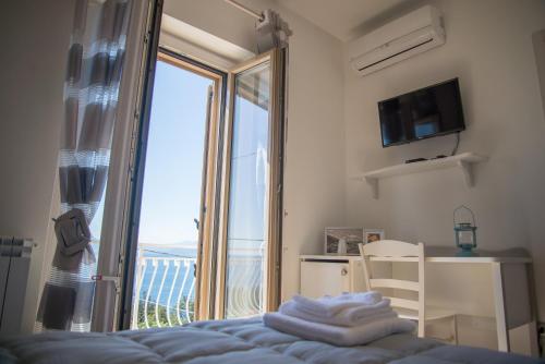 sypialnia z łóżkiem i dużym oknem w obiekcie Villa Caterina Affittacamere w mieście Maratea