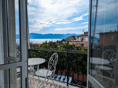 Un balcón con dos sillas y vista al agua. en La vela latina, en Lerici
