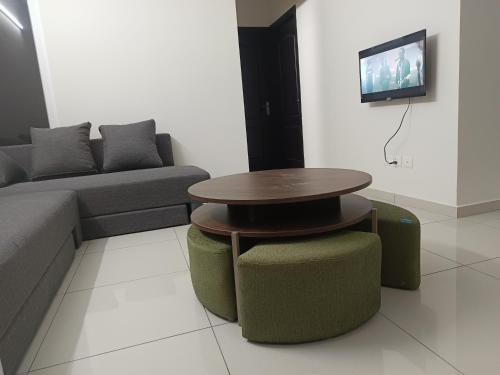 BayappanhalliにあるSkyview Retreat 2BHK near ITPL in 14th floorのリビングルーム(テーブル、ソファ、テレビ付)
