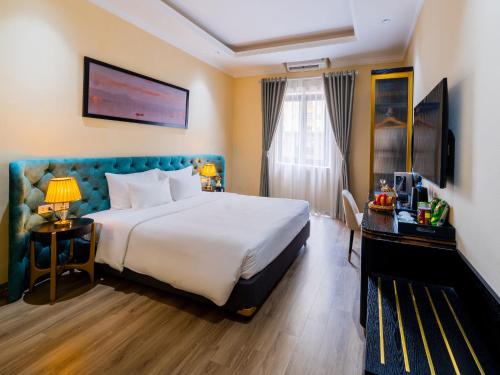 a hotel room with a large bed and a television at San Hotel & Spa in Hanoi
