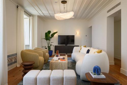 a living room with a white couch and chairs at Casagrand Luxury Apartments Lisboa in Lisbon