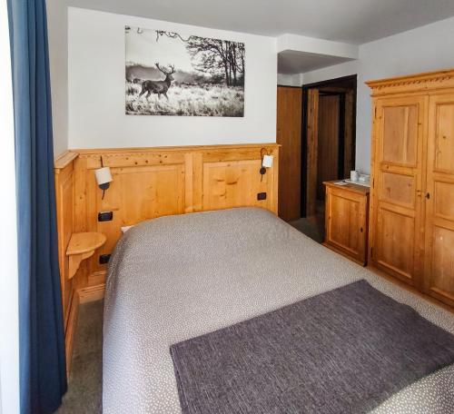 a bedroom with a bed and a picture of deer on the wall at Shackleton Chalet in Sestriere
