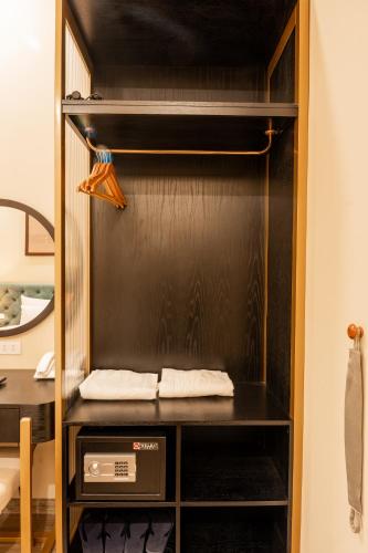 a closet with a black cabinet with a microwave at San Hotel & Spa in Hanoi