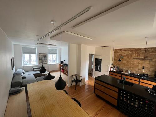 a large living room with a couch and a kitchen at Townhouse with private garden in the centre in Odense