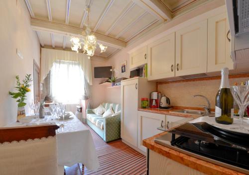 コルトーナにあるAppartamento Il Teatroの白いキャビネット付きのキッチン、リビングルーム