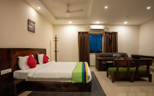 a bedroom with a bed and a couch and a chair at Hotel Shubham Grand in Bhubaneshwar