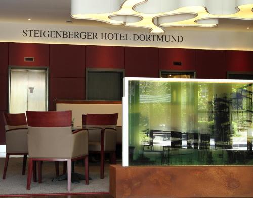 a restaurant with a table and chairs in a building at Steigenberger Dortmund in Dortmund
