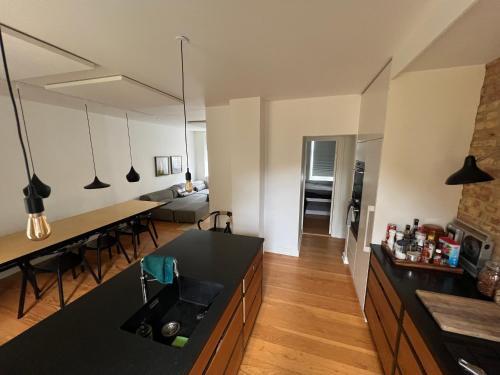 a kitchen and living room with a black counter top at Townhouse with private garden in the centre in Odense