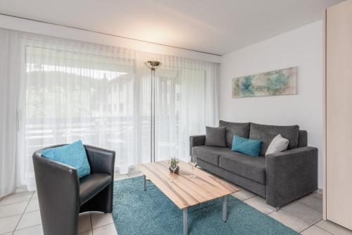 a living room with a couch and a table at Zuhause in den Alpen Ihre Ferienwohnung mit Hallenbad und Sauna in Lenzerheide