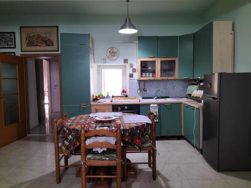 a kitchen with a table with chairs and a refrigerator at Artemide B&B in Caltagirone