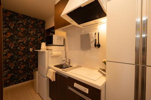 a small kitchen with a sink and a refrigerator at Park side stay Shinjuku in Tokyo