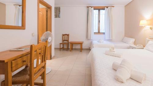 a hotel room with two beds and a desk at Hostal Centro in Toledo