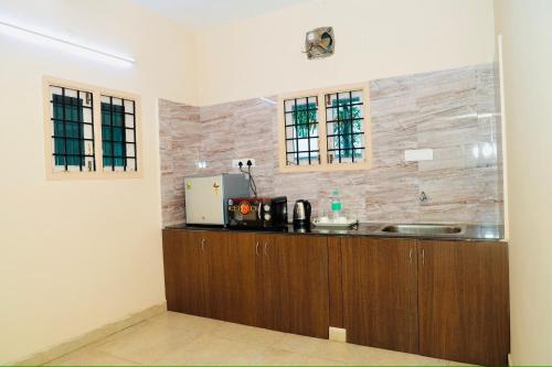 a kitchen with a sink and a counter top at Siesta Inn - RP Resort in Chennai