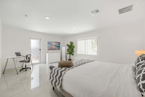 a white bedroom with a bed and a desk at Modern 4BR Retreat with Private Pool - Near Brickell in Miami
