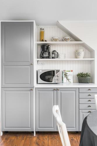 a kitchen with white cabinets and a microwave at Linden 1 in Gullberg