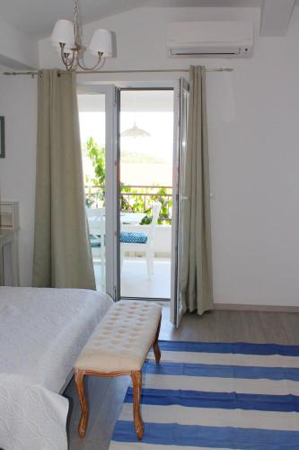 a bedroom with a bed with a bench on a blue rug at Adriona apartments with parking in Makarska