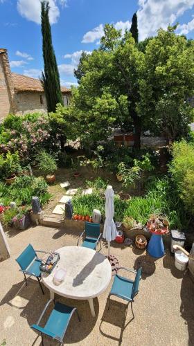 a patio with a table and chairs in a garden at Le N 9 in Argeliers