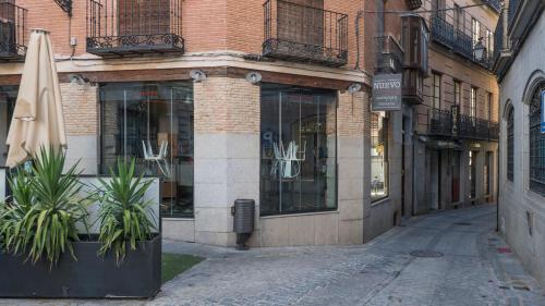 a street with a building with a umbrella on the side at Hostal Centro in Toledo