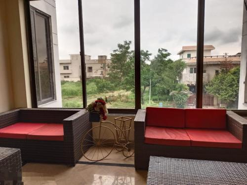 a room with two couches in front of a large window at ROYALE VISTA by MIR in Islamabad