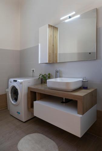 a bathroom with a sink and a washing machine at Dormen in Guspini