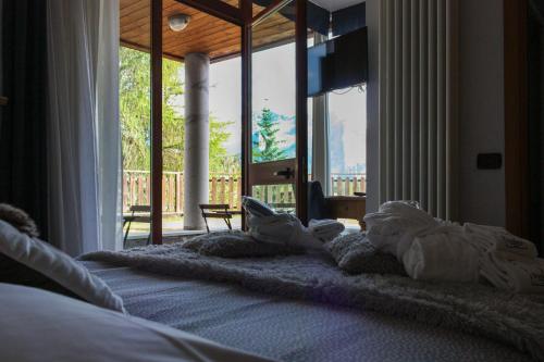 a bedroom with a large bed with a large window at Shackleton Chalet in Sestriere